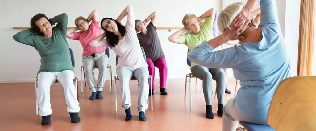 mujeres senior realizando actividad yoga en silla
